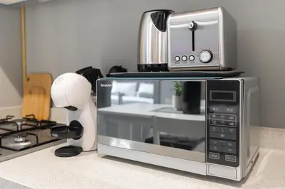 a microwave sitting on top of a kitchen counter at White Sage - DAMAC Zada Tower in Dubai