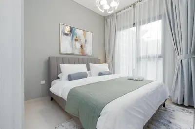 a bedroom with a large bed and a window at White Sage - DAMAC Zada Tower in Dubai