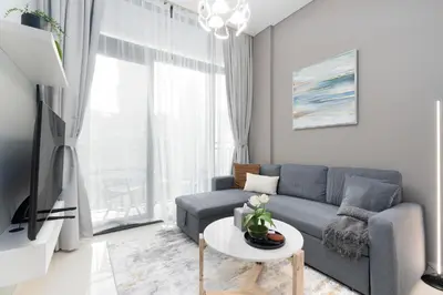 a living room with a couch and a table at White Sage - DAMAC Zada Tower in Dubai
