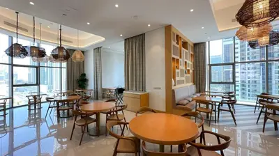 a restaurant with tables and chairs and large windows at Stunning 2BR with Burj Views Infinity Pool in Dubai
