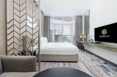 a hotel room with a bed and a tv at White Sage - Fancy Studio With Mesmerizing Canal Views in Dubai