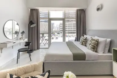 a bedroom with a bed and a desk and a window at Frank Porter - Oasis Tower 1 in Dubai