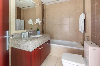 a bathroom with a sink and a tub and a toilet at Frank Porter - Oasis Tower 1 in Dubai