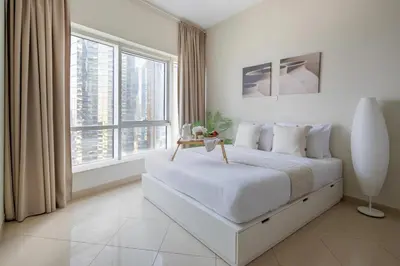 a white bedroom with a large bed and large windows at Frank Porter - Concorde Tower in Dubai