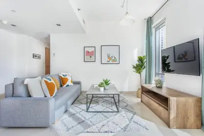 a living room with a blue couch and a table at Frank Porter - Blakely Tower in Dubai