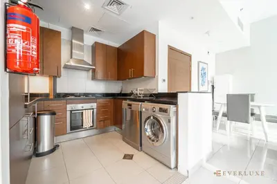 a kitchen with a washer and dryer in it at Everluxe Lovely Studio Apt In Business Bay in Dubai
