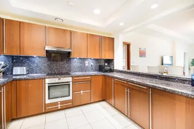 a large kitchen with wooden cabinets and stainless steel appliances at Daniels Sea View 2BR in Fairmont The Palm in Dubai