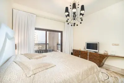 a bedroom with a large bed and a television at Daniels Sea View 2BR in Fairmont The Palm in Dubai