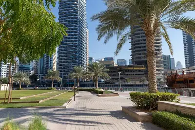 a park with palm trees and buildings in a city at Frank Porter - Panoramic Tower in Dubai