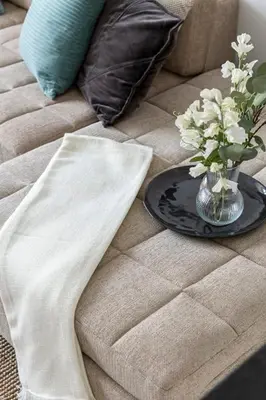 a vase of flowers on a plate on a couch at Frank Porter - Tower 108 in Dubai