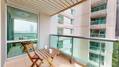 a balcony with a wooden table and chairs on it at Al Murjan - Appealing Two Bedroom in Dubai