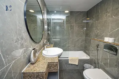 a bathroom with a sink and a toilet and a mirror at Luxury Escapes - Spacious Studio with Balcony & Marina View - Bay Central in Dubai