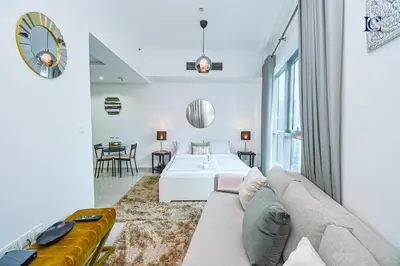 a living room with a couch and a table at Luxury Escapes - Spacious Studio with Balcony & Marina View - Bay Central in Dubai