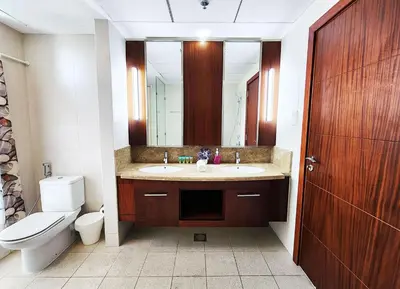 a bathroom with a sink and a toilet and a mirror at RH- The Perfect Family Getaway, 3BR in Standpoint Tower in Dubai