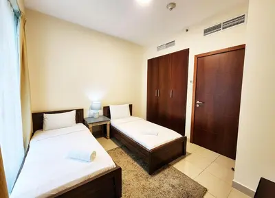 a small room with two beds and a door at RH- The Perfect Family Getaway, 3BR in Standpoint Tower in Dubai