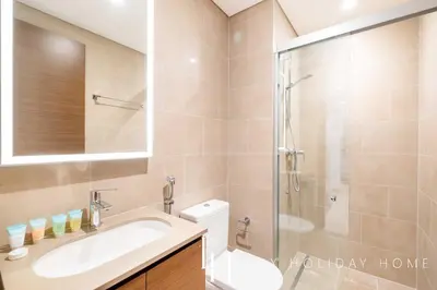 a bathroom with a shower and a sink and a toilet at LUX The Executive Sobha Suite 2 in Dubai