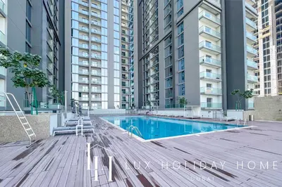 a swimming pool in front of some tall buildings at LUX The Executive Sobha Suite 2 in Dubai