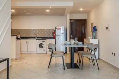 a kitchen with a table and chairs and a refrigerator at 1BDR Apartment I Close To Metro I Marina Diamond 4 in Dubai