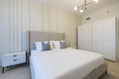 a bedroom with a white bed and a white cabinet at 1BDR Apartment I Close To Metro I Marina Diamond 4 in Dubai