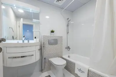 a white bathroom with a toilet and a tub and a sink at 1BDR Apartment I Close To Metro I Marina Diamond 4 in Dubai