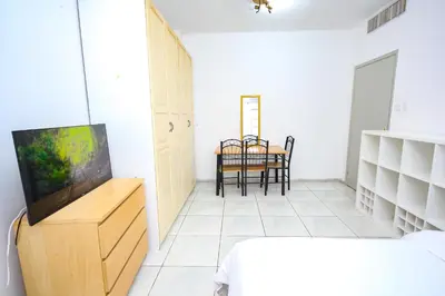 a bedroom with a table and a tv in a room at Relaxing Private Rooms in Compound Housing near Burj Alarab Villa 124 in Dubai