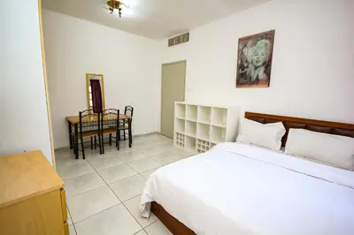 a bedroom with a bed and a table and a chair at Relaxing Private Rooms in Compound Housing near Burj Alarab Villa 124 in Dubai