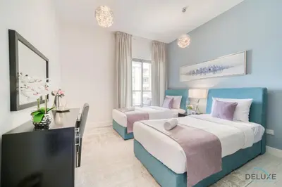 a hotel room with two beds and a television at Exquisite 2BR At Shams 1 JBR by Deluxe Holiday Homes in Dubai