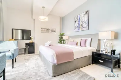 a bedroom with a bed and a desk and a television at Exquisite 2BR At Shams 1 JBR by Deluxe Holiday Homes in Dubai