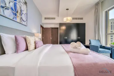a bedroom with a large bed with pink and white pillows at Exquisite 2BR At Shams 1 JBR by Deluxe Holiday Homes in Dubai