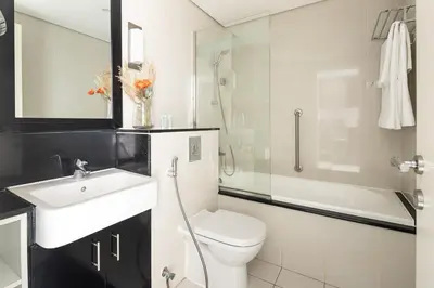 a bathroom with a toilet and a sink and a shower at Frank Porter - Damac Cour Jardin in Dubai