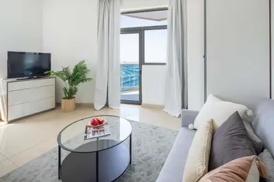 a living room with a couch and a glass table at Frank Porter - Yach Bay in Dubai