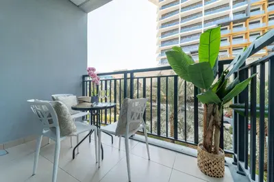 a balcony with a table and chairs and a plant at Frank Porter - Sunrise Legend in Dubai