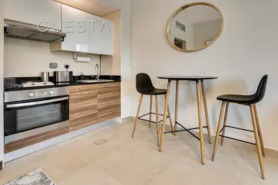 a kitchen with a table and two chairs and a mirror at Sparkle Tower - Studio, Dubai Marina in Dubai