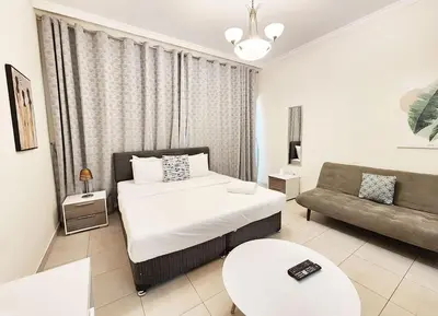 a bedroom with a bed and a couch at RH- Relaxing Studio, Downtown with private balcony, walk away from Burj Khalifa in Dubai