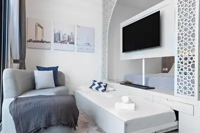 a living room with a white couch and a tv at Unique Dubai Marina Studio, near Jumeirah Beach, Mall and Metro in Dubai