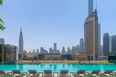 a swimming pool with chairs and a city skyline at Frank Porter - Downtown Views 2 in Dubai