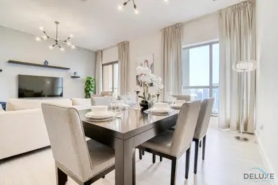 a dining room and living room with a table and chairs at Stylish 2BR At Shams 1 JBR by Deluxe Holiday Homes in Dubai