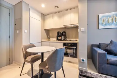 a kitchen with a table and chairs and a couch at ALiving Luxury 1BR with Canal View I Near Burj Khalifa & Dubai Mall I Zada Tower, 2613 in Dubai