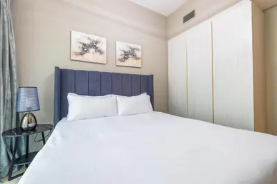 a bedroom with a white bed and a blue headboard at ALiving Luxury 1BR with Canal View I Near Burj Khalifa & Dubai Mall I Zada Tower, 2613 in Dubai