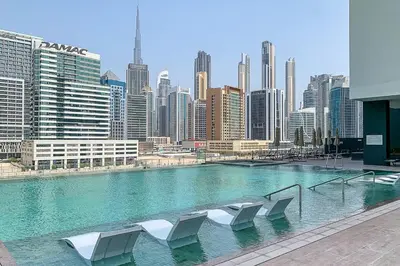 a large swimming pool with white chairs in a city at Frank Porter - 15 Northside Tower 2 in Dubai