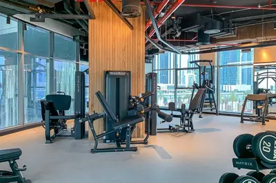 a gym with cardio equipment in a building with windows at Frank Porter - 15 Northside Tower 2 in Dubai