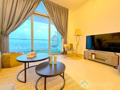 a living room with two tables and a large window at Luxury Stop w/ BoHo Design & Sea View in Marina in Dubai
