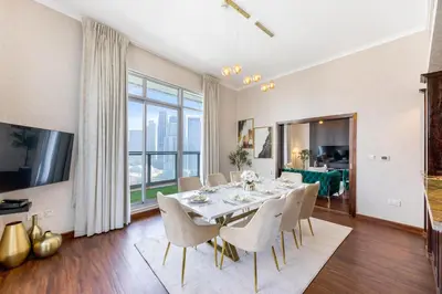 a dining room with a table and chairs and a large window at Durrani Homes - Alluring 5BR Penthouse with Burj Khalifa and Fountain View in Dubai