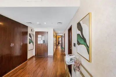 a hallway with wood floors and paintings on the walls at Durrani Homes - Alluring 5BR Penthouse with Burj Khalifa and Fountain View in Dubai