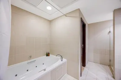a white bathroom with a tub and a shower at Durrani Homes - Alluring 5BR Penthouse with Burj Khalifa and Fountain View in Dubai