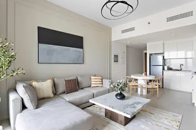 a living room with a couch and a table at Silkhaus luxurious 1BDR in new tower with pool & gym in Dubai
