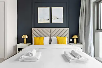 a bedroom with a white bed with towels on it at Silkhaus luxurious 1BDR in new tower with pool & gym in Dubai