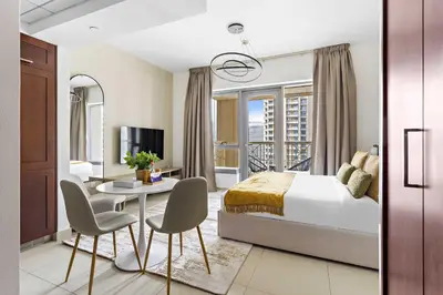 a bedroom with a bed and a table and chairs at Silkhaus beautiful studio in Downtown near Burj Khalifa in Dubai