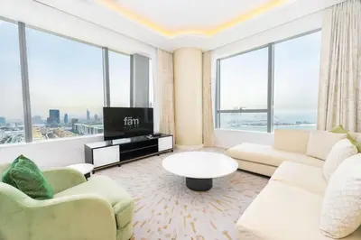 a living room with a couch and a tv at FAM Living - Palm Tower Attached to St Regis Palm Tower 1Bed - Palm Jumeirah Views in Dubai