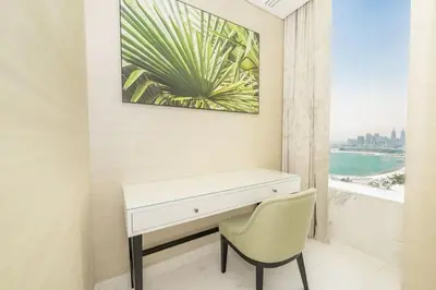 a white desk and a chair in a room with a window at FAM Living - Palm Tower Attached to St Regis Palm Tower 1Bed - Palm Jumeirah Views in Dubai